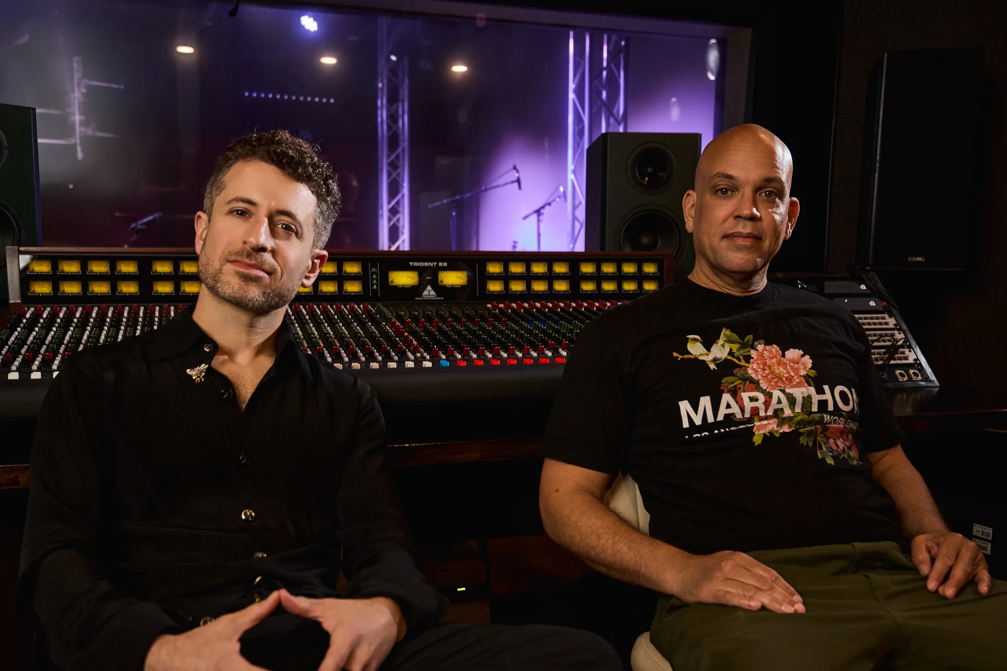 Two of the club’s engineers at the Trident console, the Live Room lit purple through the glass behind them
