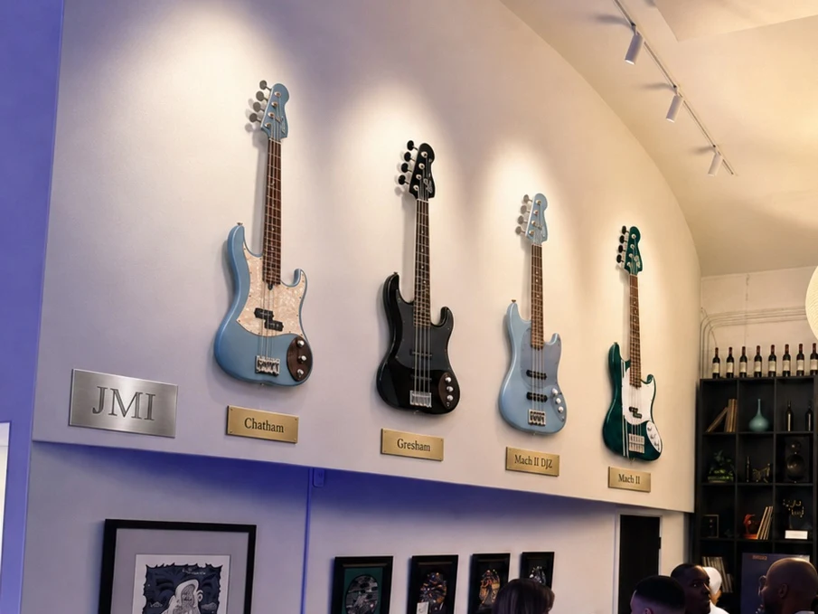 The Jones Musical Instruments wall at the Club: four basses on brass-plaqued mounts