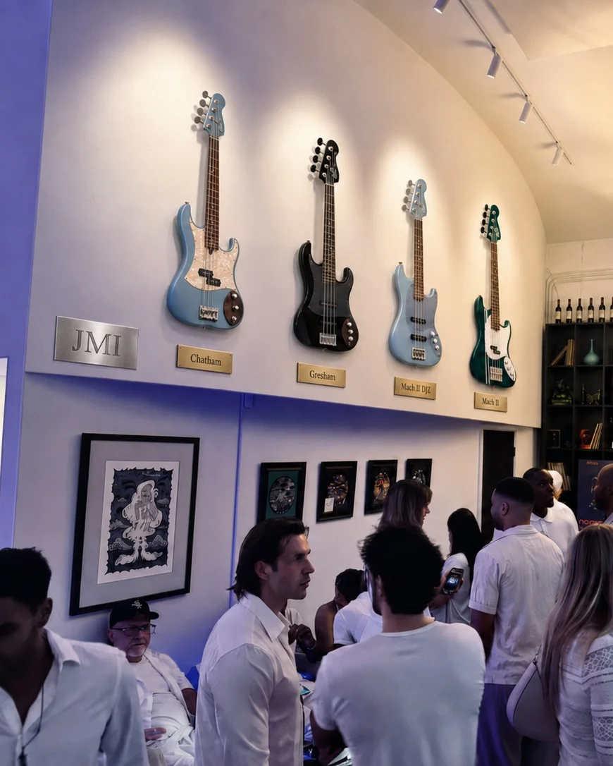 The Jones Musical Instruments wall at the Club: four basses on brass-plaqued mounts above the evening crowd